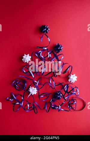 Christmas tree made of shiny blue ribbon with bows. Stock Photo