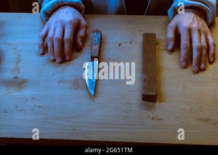 https://l450v.alamy.com/450v/2g651tm/hands-and-an-old-knife-homemade-knife-old-rusty-knife-and-whetstone-homemade-knife-restoration-2g651tm.jpg