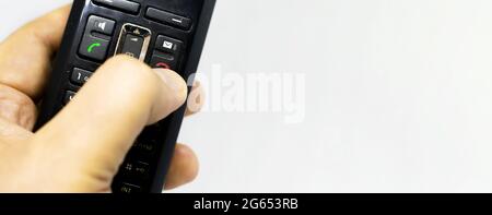 Thumb pushing the button with the red icon to reject or hang up a call on the phone. Landline telephony. Wireless phone. Copy space Stock Photo