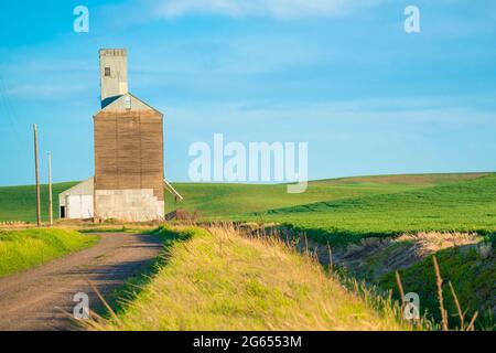 View of industrial grain elevator seen from wheat farm in the Palouse Washington state Stock Photo