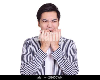 young man, showing  surprised or worried expression, and biting his fingers. Isolated on white background Stock Photo