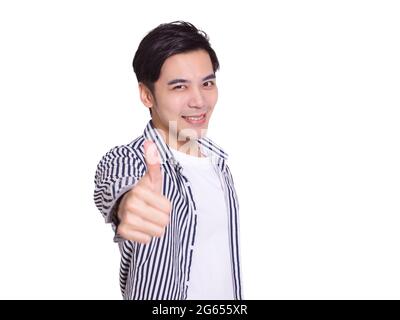 young man smiling and making thumbs up gesture Stock Photo