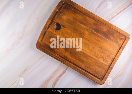Rectangular shaped wood cutting board on dark concrete background. Top view with copy space for text. Stock Photo