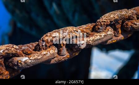 Old rusty Iron Chain holding the boats anchor. Stock Photo