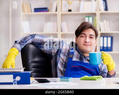 The male cleaner working in the office Stock Photo