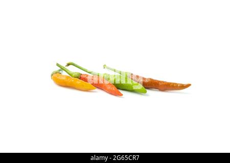 Fresh hot chili peppers of various colors are placed isolated on a white background. Stock Photo