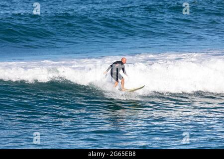 Male surfer riding the ocean wave at Avalon Beach in Sydney,Australia Stock Photo