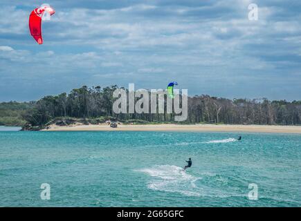 kiteboarders are pulled across water by power kites at Sandy Cove in the estuary of the Noosa River at Noosa Heads, Sunshine Coast, Queensland, Austra Stock Photo