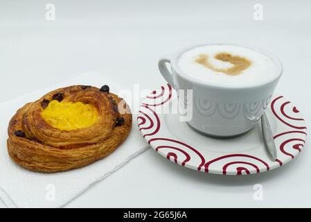 Traditional Italian breakfast, Cappuccino coffee with raisins cream brioche, isolated on white background. Stock Photo