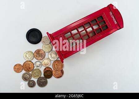 British piggy bank with a group of British coins isolated on white background Stock Photo