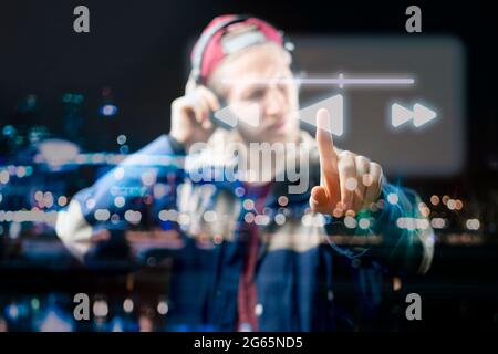 atrractive male use futuristic device to listen to music Stock Photo
