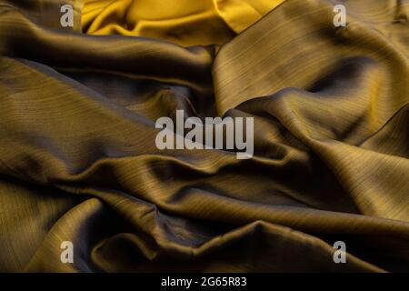 Fragment of yellow and green tissue. Side view, synthetic textile background and texture. wave concept, abstract. Stock Photo