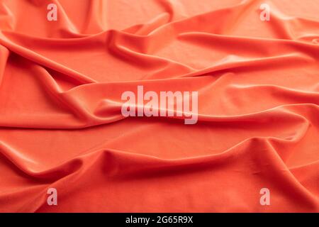 Fragment of red silk tissue. Side view, natural textile background and texture. wave concept, abstract. Stock Photo