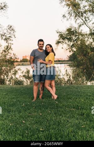 Beautiful barefoot couple standing and posing in park Stock Photo