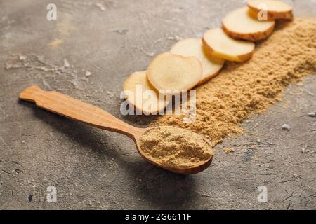 Spoon with ginger powder on grunge background, closeup Stock Photo