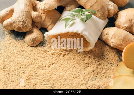 Ginger powder and roots on table, closeup Stock Photo