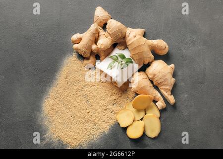 Ginger powder and roots on dark background Stock Photo