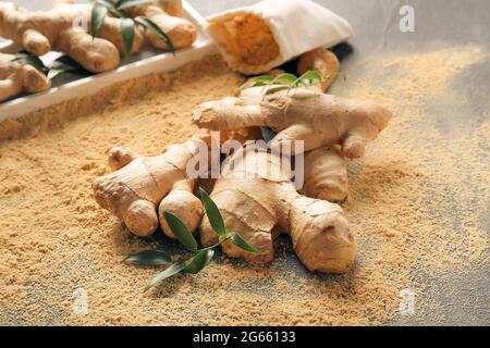 Ginger powder and roots on dark background Stock Photo