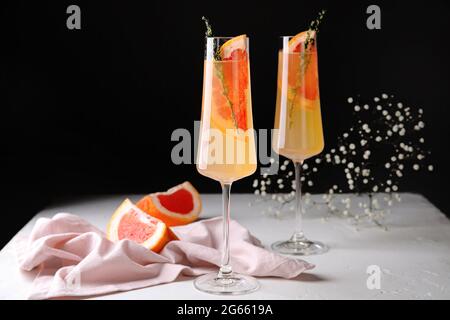 Glasses of tasty grapefruit cocktail on black and white background Stock Photo