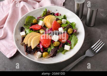Plate with tasty grapefruit salad on grunge background Stock Photo