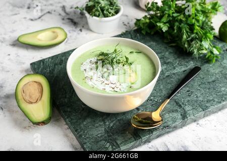 Bowl with green gazpacho and ingredients on grunge background Stock Photo