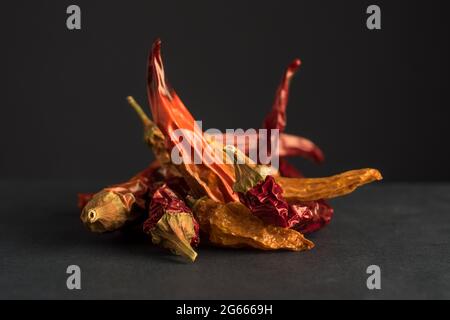 Dried red and yellow chillies on dark background Stock Photo