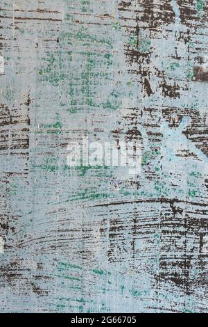 Old painted blue and green wall with gray and black base. Weathered peeling surface. Abstract colored background. Vertical position Stock Photo