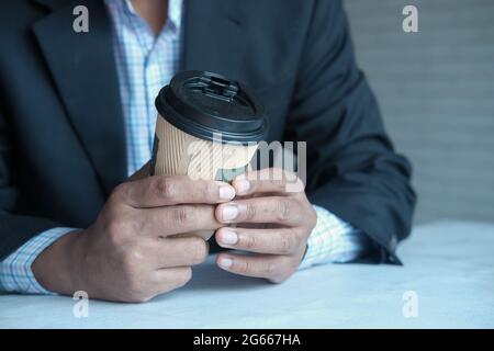 businessman hand holding take away paper cup white sited  Stock Photo