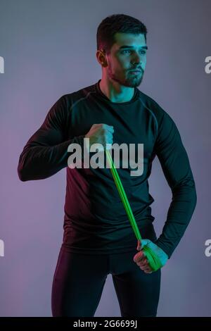 Young man warming up with resistance band before workout Stock Photo