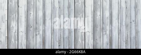 Light gray, partly weathered wooden wall made of vertical boards Stock Photo