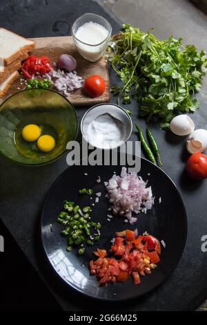 Chopped vegetable ingredients onion, tomato and green chillies on a plate with use of selective focus Stock Photo