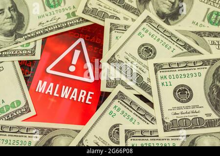 Hacking the personal data, money banknote on the background and malware sign on the screen Stock Photo
