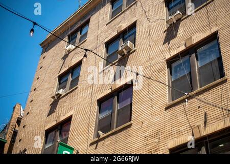 Air conditioners sprout from windows in a building in New York on Thursday, June 24, 2021. © Richard B. Levine) Stock Photo