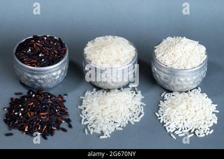 Three types of rice in a silver container. On a gray background and copy-space. Stock Photo