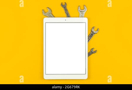 Industry and construction mockup with tablet, blank white screen, table with tool kit, yellow background, top view, flat lay and copy space Stock Photo