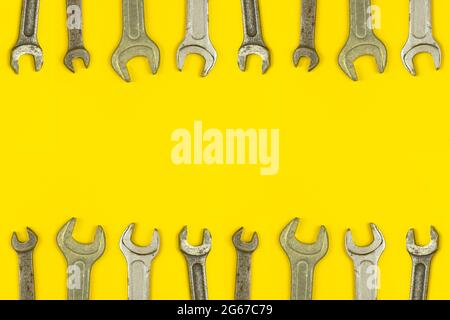 Various wrench tools border backround, yellow worker table workspace concept, top view and copy space Stock Photo