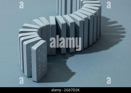 Light Blue wood domino pieces on light blue background. Leisure games concept. Stock Photo