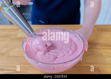 ice cream cooking process with strawberries and yogurt in a bowl with a blender Stock Photo