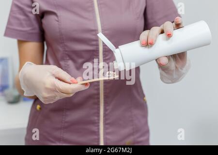 Cosmetologist preparing anesthetic gel for laser epilation. Laser hair removal without pain in spa salon Stock Photo