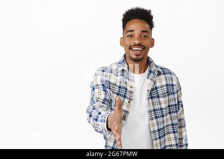 Nice to meet you. Friendly smiling african american man extend hand for handshake, greeting, saying hello, attend meeting and welcome someone, white Stock Photo