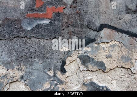 Old dark scratched plaster wall background. Black worn brickwall with peel grey stucco texture. Abstract decayed cracked rough painted wall surface Stock Photo