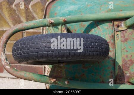 Close up of used wheelbarrow seen discarded against a wall. Stock Photo