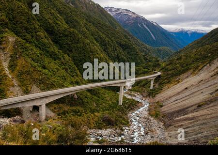 Highway through the mountains on Arthurs Pass viaduct winding through the rugged Otira Gorge Stock Photo