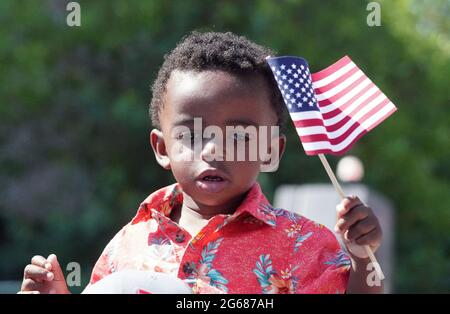 St. Louis, United States. 03rd July, 2021. Jeffrey Tesreau, 19 months, waves an American flag as America's Birthday Party Parade begins in downtown St. Louis on Saturday, July 3, 2021. Photo by Bill Greenblatt/UPI Credit: UPI/Alamy Live News Stock Photo