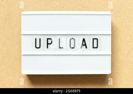 Lightbox with word upload on wood background Stock Photo