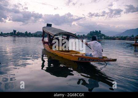 Srinagar, India. 04th July, 2021. A Kashmiri man rows his shikara boat on Dal Lake during an evening.Weathermen forecast mainly “hot and dry” weather in Jammu and Kashmir for the next five days. (Photo by Idrees Abbas/SOPA Images/Sipa USA) Credit: Sipa USA/Alamy Live News Stock Photo