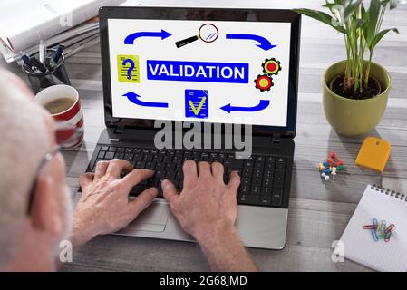 Validation concept shown on a laptop used by a man Stock Photo