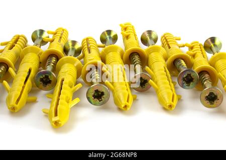 Screw anchor or dowel, yellow, isolated on white background. Stock Photo
