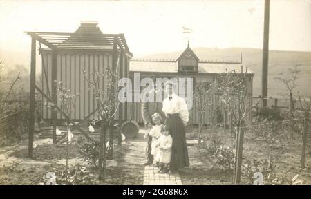 Portrait of young family in their vegetable garden beside their pigeon loft circa 1905 Stock Photo