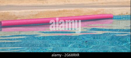 Swimming Pool with Float. Closeup. Copy Space. Pink floating snake with abstract  pink water ripples. Stock Image. Stock Photo